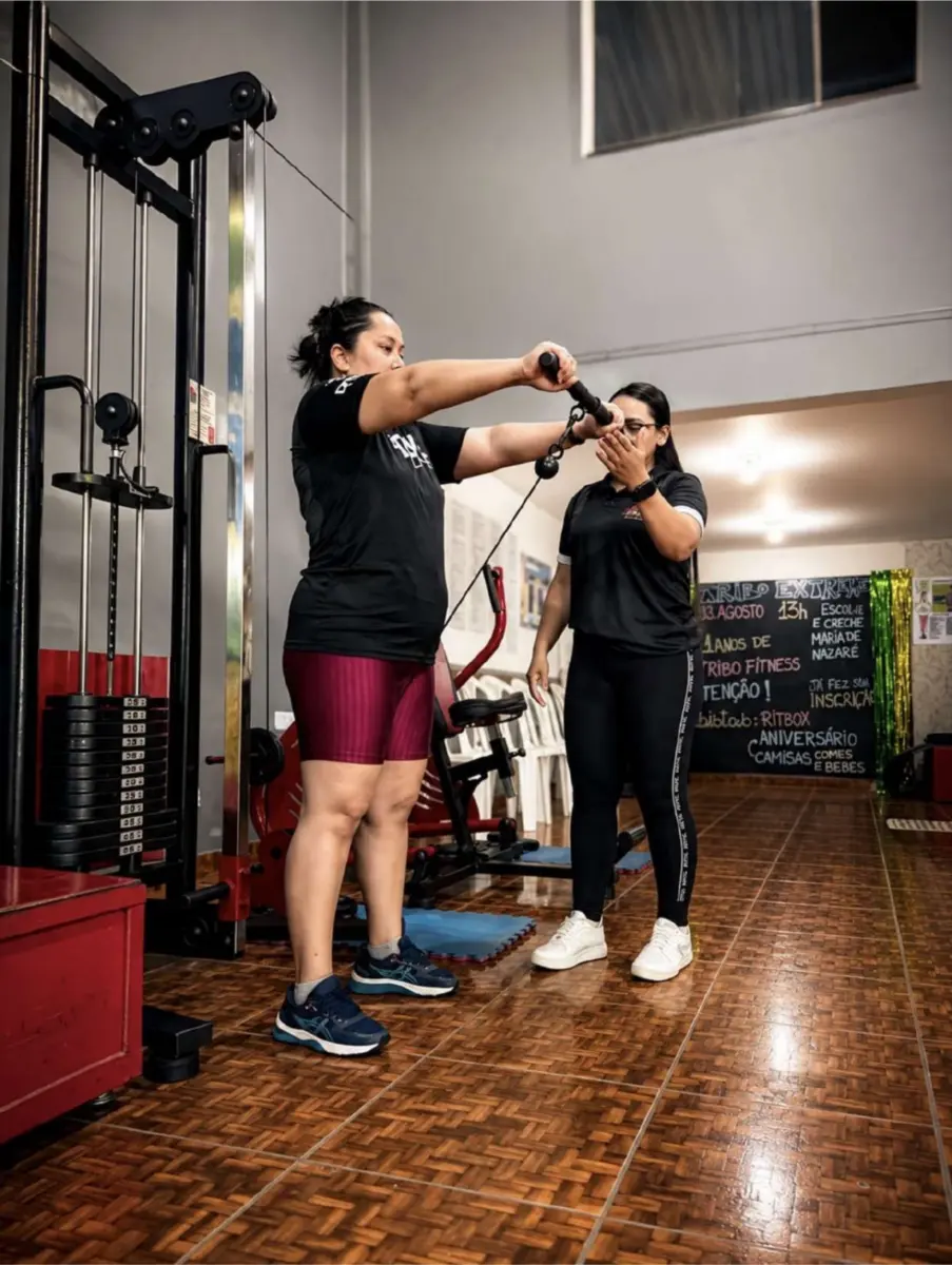 Aluna treinando no equipamento de cabos