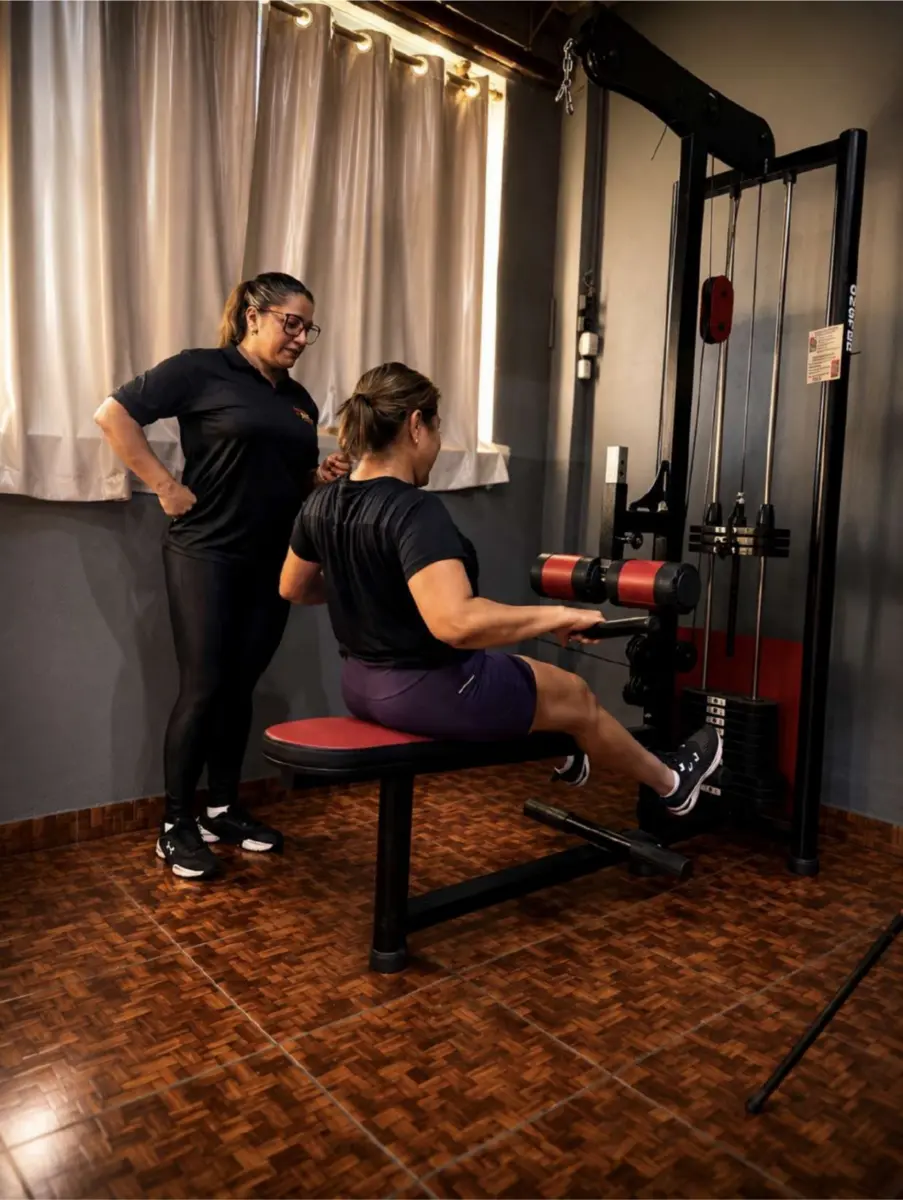 Professora orientando exercício no aparelho